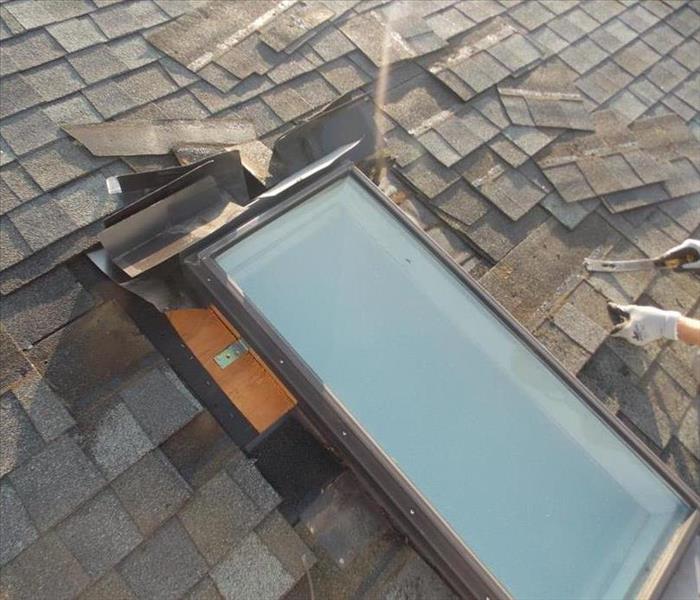 image of shingles removed around a skylight on top of a roof