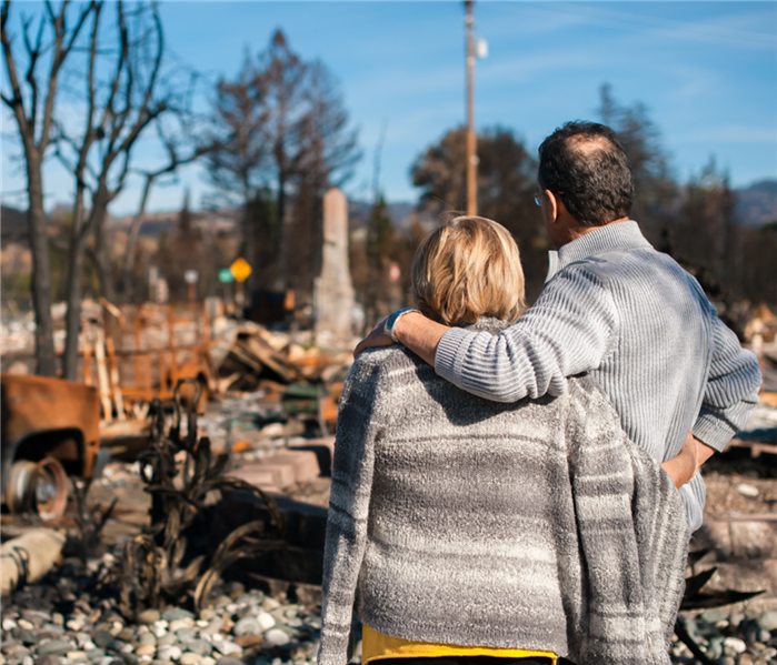 couple looking at remains of home